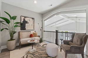 Living area featuring lofted ceiling with beams and hardwood / wood-style floors