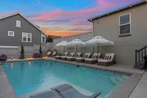 Pool at dusk featuring a patio