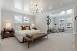 Bedroom with multiple windows, light carpet, wooden ceiling, and crown molding