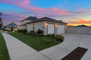 Property exterior at dusk with a garage and a yard