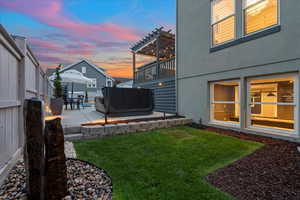 Yard at dusk with a patio and a pergola