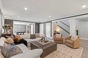 Living room with billiards, light hardwood / wood-style floors, and crown molding