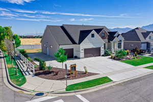 Modern inspired farmhouse featuring fence, an attached garage, board and batten siding, driveway, and a mountain view