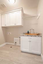 Laundry room featuring washer hookup, hookup for an electric dryer, baseboards, visible vents, and cabinet space
