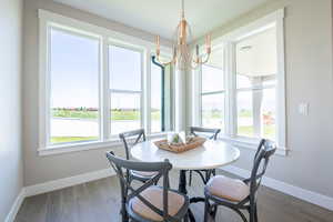 Dining space featuring dark wood finished floors, baseboards, and an inviting chandelier