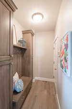 Mudroom featuring baseboards, visible vents, light wood-style flooring, and a textured ceiling