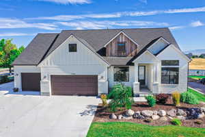 Modern farmhouse featuring driveway, a shingled roof, a garage, and board and batten siding