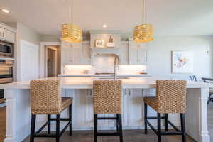 Kitchen with light countertops, decorative backsplash, and stainless steel appliances