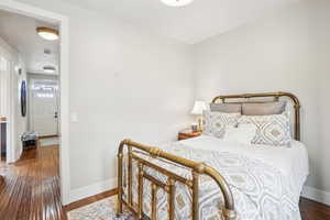 Bedroom with dark hardwood / wood-style flooring