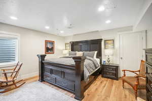 Bedroom featuring a textured ceiling and light hardwood / wood-style flooring