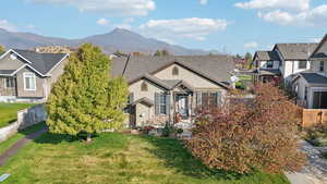 View of front facade featuring a mountain view and a front lawn