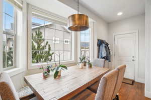 Dining space with dark wood-type flooring and a healthy amount of sunlight