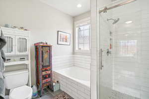 Bathroom featuring toilet, tile patterned floors, and separate shower and tub