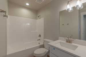 Full bathroom with vanity, shower / washtub combination, and toilet