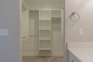 Spacious closet with light colored carpet