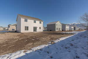 Snow covered rear of property featuring a mountain view