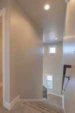 Staircase with carpet and a textured ceiling