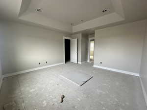 Unfurnished bedroom featuring a tray ceiling