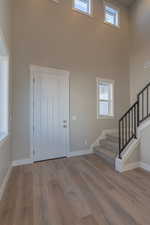 Entryway with a towering ceiling and light hardwood / wood-style flooring