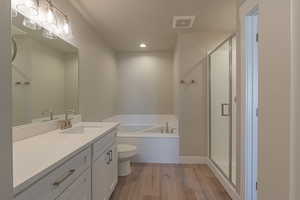 Full bathroom with shower with separate bathtub, hardwood / wood-style floors, vanity, and toilet