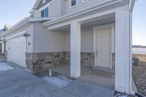 Doorway to property featuring a garage, covered porch, and central air condition unit