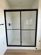 Bathroom featuring wood-type flooring and walk in shower