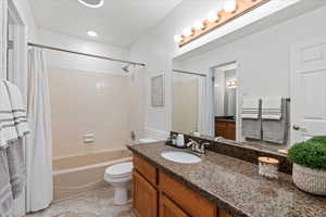 Full bathroom with vanity, tile patterned floors, toilet, and shower / tub combo with curtain