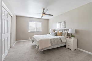 Carpeted bedroom with a closet and ceiling fan