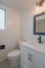 Bathroom with vanity, toilet, and tile patterned flooring