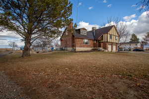 View of side of home with a garage and a lawn