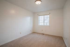 Empty room featuring light carpet