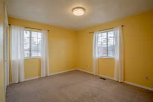 Carpeted empty room with a textured ceiling