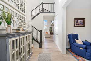 Foyer entrance featuring light  LVP flooring and a high ceilings