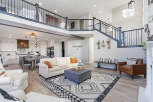 Living room featuring light LVP flooring and a high ceiling , natural light