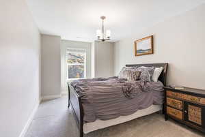 Carpeted bedroom featuring a notable chandelier