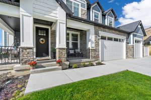 View of exterior entry featuring a yard and covered porch