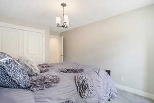 Bedroom with carpet flooring, a closet, and an inviting chandelier