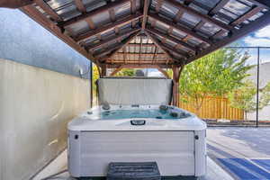 View of patio featuring a hot tub (included) and a gazebo