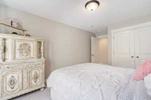 Bedroom featuring light colored carpet and a closet