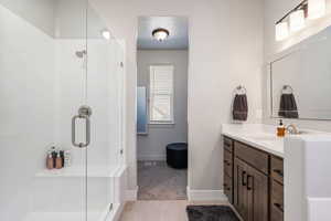 Bathroom featuring walk in shower, vanity, a textured ceiling, and tile patterned flooring, his & her walk-in closet