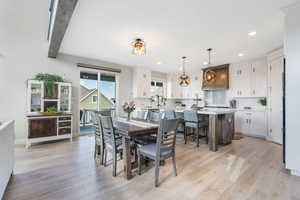 Dining space featuring sink, backsplash, beamed ceiling