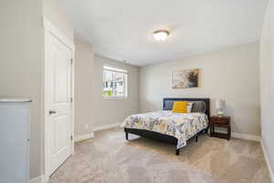 Bedroom featuring a textured ceiling and light carpet