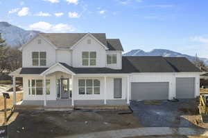 Front of home featuring a large porch, oversized 3-car garage, and mountain views