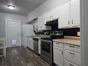 Kitchen with white cabinetry, stainless steel appliances, sink, and dark hardwood / wood-style floors