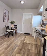 Dining room with light hardwood / wood-style floors and a textured ceiling