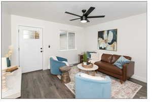 Living room with dark hardwood / wood-style floors and ceiling fan