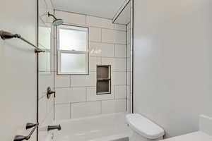 Main level Bathroom featuring toilet and tiled shower / bath