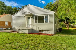 Bungalow-style house featuring central AC unit and a front yard