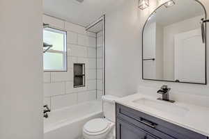 Main Level full bathroom with vanity, toilet, and tiled shower / bath