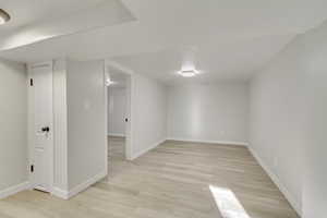 Basement with light hardwood / wood-style floors